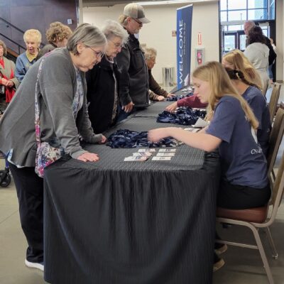 Youth in Action student volunteers register AEOA's Senior Expo attendees at Iron Trail Motors Event Center in Virginia on Wednesday, May 6, 2026.