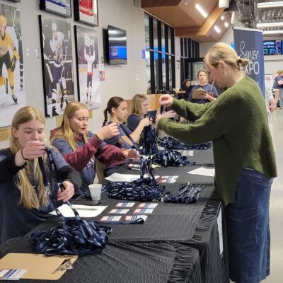Volunteer Kelly Garrity helps Youth in Action student volunteers at AEOA's registration table during the Senior Expo at Iron Trail Motors Event Center on Wednesday, May 6, 2026.