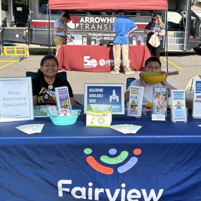 A Peer Recovery Specialist is ready to chat at Fairview Range’s table during AEOA’s block party.